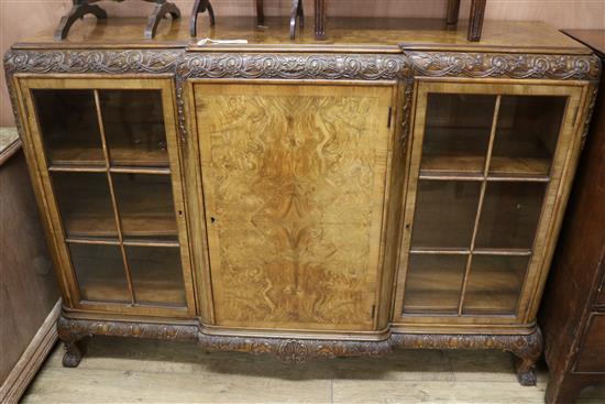 A 1930s carved and figured walnut breakfront dwarf bookcase, W.156cm